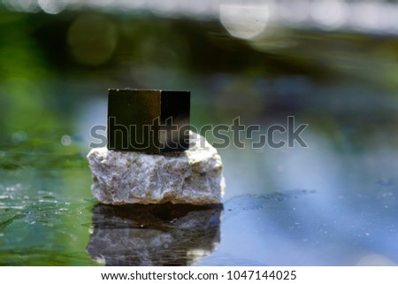 Pyrite on the wet surface, reflection in the mirror