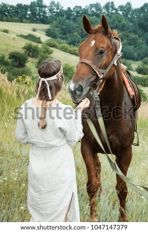 A girl in homespun clothes with a horse on the background of the steppe