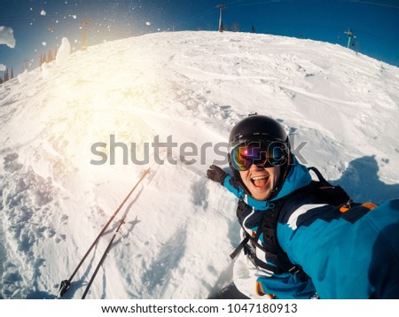 Guy sportsman goes on normal skiing on ski slope with action camera. Sunset. Sheregesh, Kemerovo region, Russia.