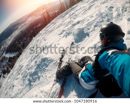 Guy sportsman goes on normal skiing on ski slope with action camera. Sunset. Sheregesh, Kemerovo region, Russia.