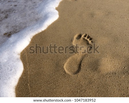 Waves and footprints on a sandy beach