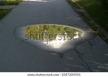Puddles on the city road. Summer and autumn background 