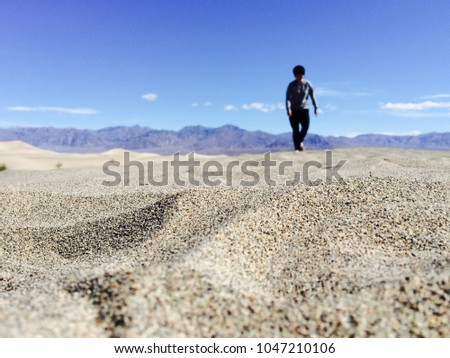 
People is walking on the sand with mountain background.