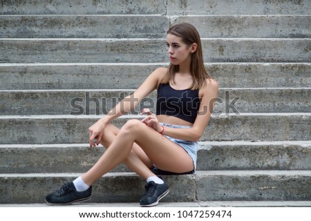Young beautiful girl sitting on the stairs copy space Horizontal photo
