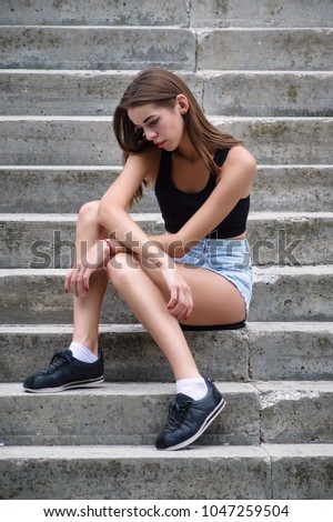 Young beautiful girl sitting on the stairs Vertical photo