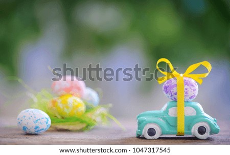 Toy car carrying easter egg in spring time
