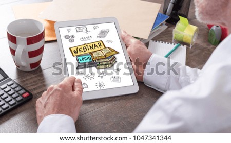 Webinar concept shown on a tablet held by a man