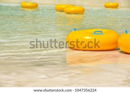 Yellow swimmer rings waiting for players in the pool in sunny day on summer.Simulated sea.holidays,summer,vacation concept.copy space for add text.
