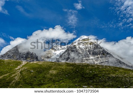 Green forests and snow mountains, dark clouds