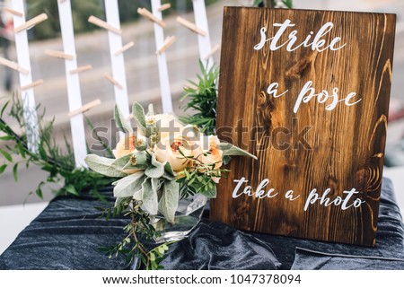 Wooden decorative frame stands on the table on the top. Welcome sign. Reception