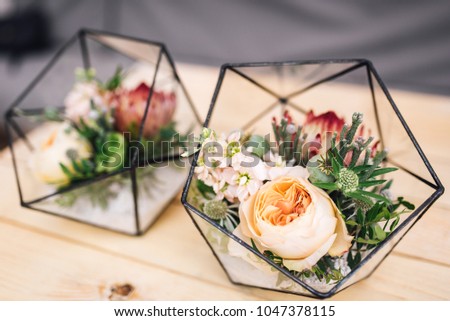 Little glass vase with fresh bouquet stands on the table. Wedding decor
