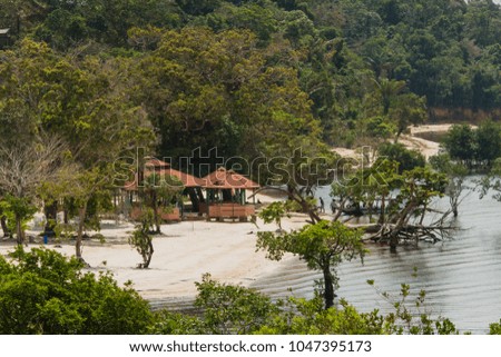 River island with huts at 'Rio Negro' river. Sunny day in the flooded rainforest. Manaus, Amazon / Brazil