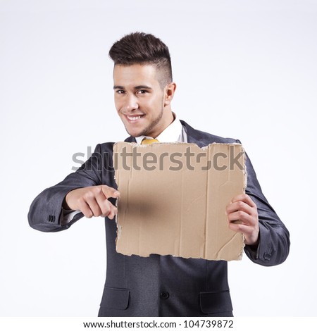 Happy young businessman holding a blank piece of cardboard