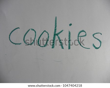 Text cookies hand written by green oil pastel on white color paper