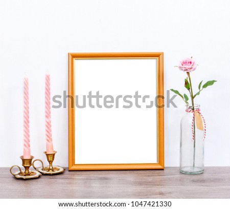 Minimalistic mockup 8x10 with pink candles and rose flower on gray rustic table. Portrait orientation.