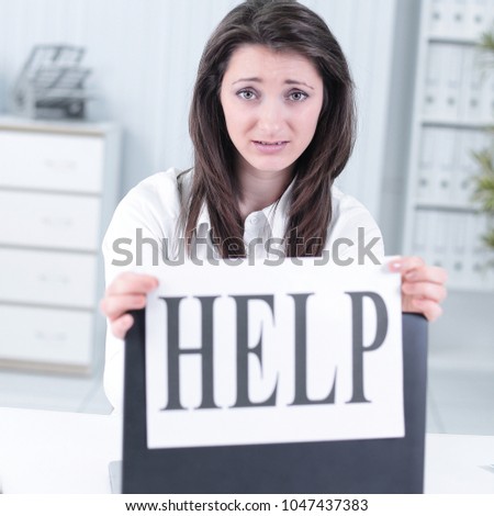 frustrated business woman showing a sheet with the word help