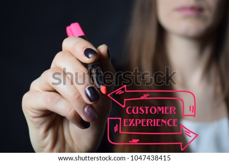 Businessman writes a red marker inscription:CUSTOMER EXPERIENCE