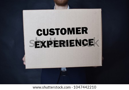 The businessman is holding a box with the inscription:CUSTOMER EXPERIENCE
