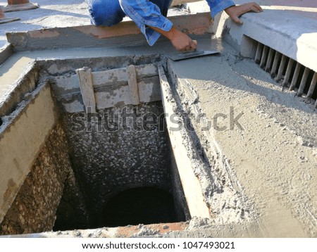 construction worker are plastering drainage on the street