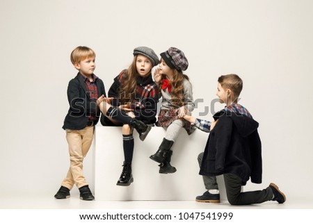 The group of beautiful teen girls and boys on a pastel studio background. Stylish young teen girls posing at studio. Classic autumn style. Teen and kids fashion concept. children's fasion concept