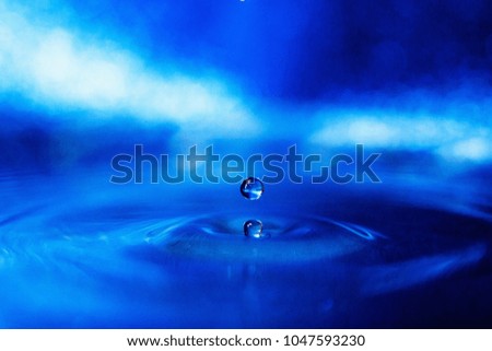 a drop of water on a blue background in smoky light