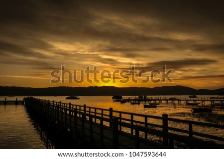 Natural sunset sunrise. Bright dramatic sky and dark ground. Countryside landscape under scenic colorful sky at sunset dawn. Sun over harbor skyline, horizon and warm colors
