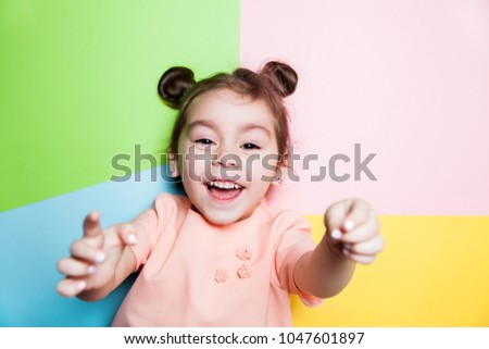 Pretty 4-year little girl with funny face on multicolor background. Bright colors and stylish picture.