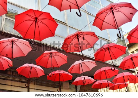 Red umbrellas hanging on the string above the 
promenade