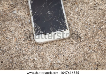 Broken smartphone fallen on a reinforced concrete floor