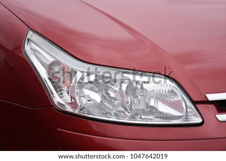 shiny headlight on a red car