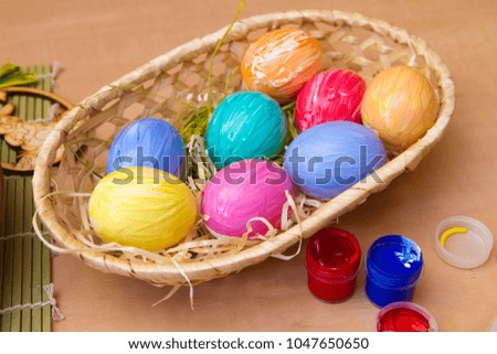 Painted eggs in a wicker basket. Easter decor.