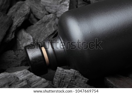 Original black matte bottle of vodka or tequila or other liqueur.On charcoal background. Black edition. Royalty-Free Stock Photo #1047669754