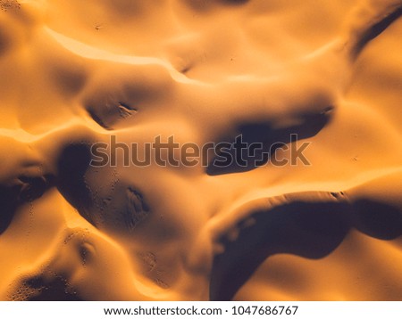 Light and shadow aerial view of golden sand.