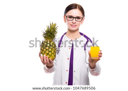 Female nutritionist hold pineapple and glass of fresh juice in her hands on white background