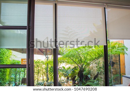 White curtains or Roller blind use sun protection and beautiful. Royalty-Free Stock Photo #1047690208