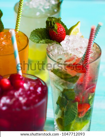 Three glasses of summer lemonade, iced tea, and pink lemonade drinks.
