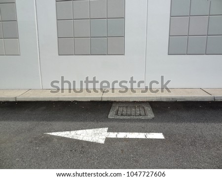 Monochromatic view of street arrow marking with building background