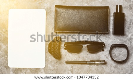 Working space. Accessories for a business woman on a concrete table. Space for text. Wallet, sheet of paper, perfume, sunglasses, smart watch, smartphone, pen.  Trend of minimalism. Top view.