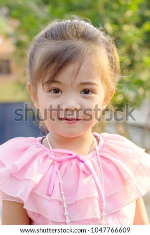 Image of sweet baby girl in pink dress, closeup portrait of cute  smiling girl. Child happiness and good healthy concept.
