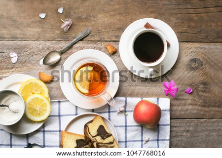 Flay lat afternoon coffee and tea break with snack on rustic wooden table top.  Royalty-Free Stock Photo #1047768016