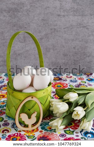 Eggs in the basket and bouquet of tulips