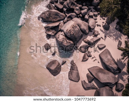 Seychelles, young man and women on the white sand beach, drone view bird eye 