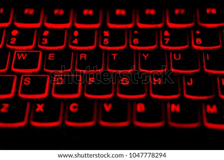 English language laptop keyboard with glowing red light for hacking ,gaming,program developing concept,soft focus