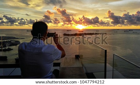 A man take picture of sunset