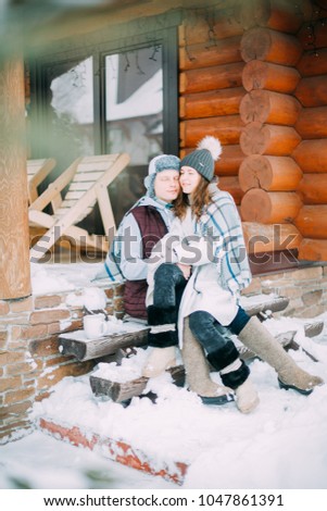 Young couple in a romantic cabin outdoors in winter
