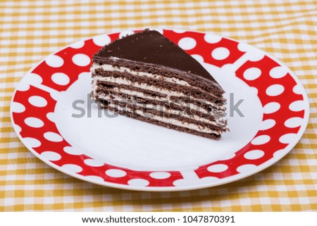 A slice of rich moist chocolate cake on a white plate with layers