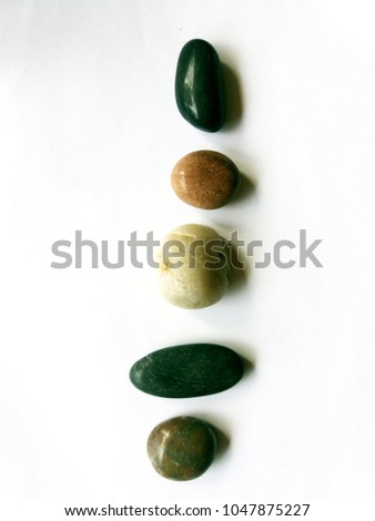 Pebbles lined up vertically on a white background.