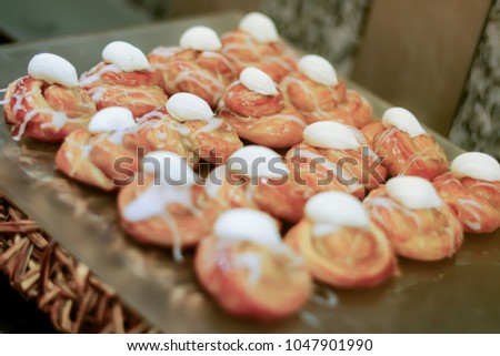 Homemade profiteroles served with blueberries on a white plate, Baked round profiteroles with white cream and cupcakes with on board, selective focus and shallow depth of field
