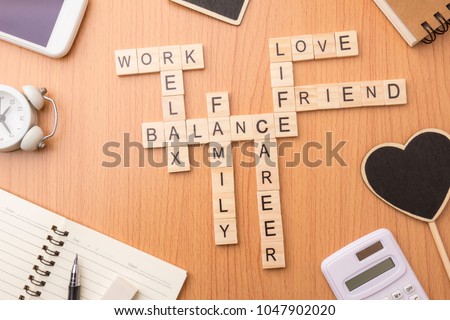 harmony and balance conception of life, work and family by letters wooden block crossword on desk background.
