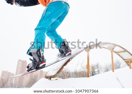 Image from bottom of sportive man skiing on snowboard with springboard